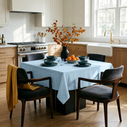 Sky Blue Square Linen Tablecloth in a Modern Kitchen with Light Wood Cabinetry and Dark Upholstered Chairs