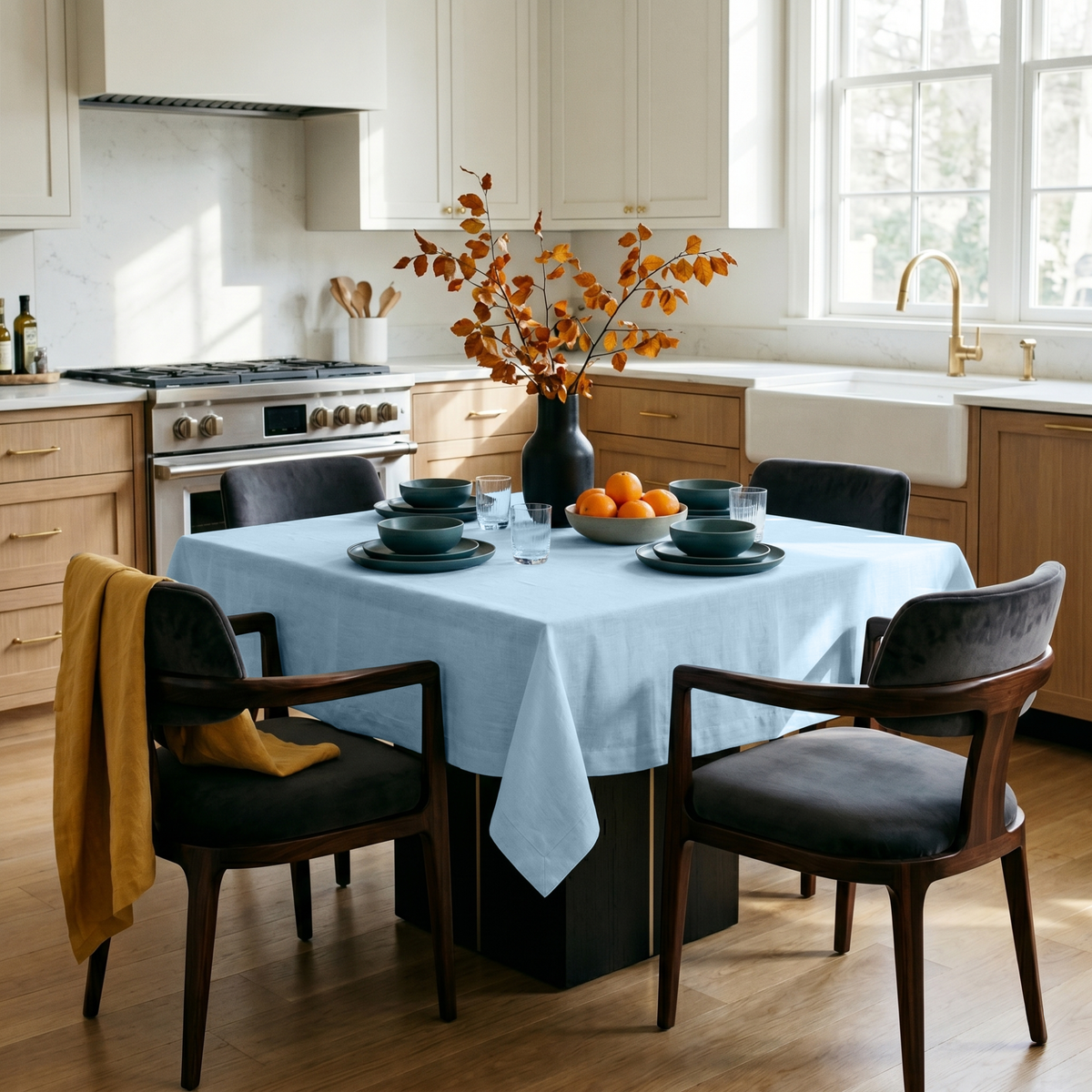 Sky Blue Square Linen Tablecloth in a Modern Kitchen with Light Wood Cabinetry and Dark Upholstered Chairs