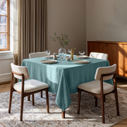 Aquamarine Blue Square Linen Tablecloth in a Transitional Dining Room with White Bouclé Chairs and Warm Wood Sideboard