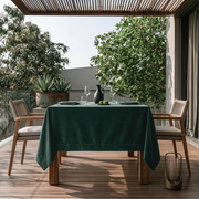 Hunter Green Square Velvet Tablecloth in a Modern Outdoor Dining Area with Wooden Armchairs