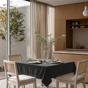 Dark Grey Square Velvet Tablecloth in a Minimalist Dining Area with Light Wood Cabinetry and Cane Chairs