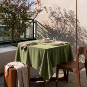 Olive Green Square Velvet Tablecloth in a Minimalist Outdoor Dining Area with Wooden Furniture