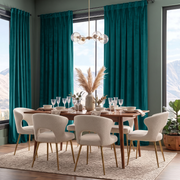 A luxurious dining room with rich teal curtains, panoramic mountain views, a wooden table, cream bouclé chairs with gold legs, elegant glassware, and a pampas-grass centerpiece
