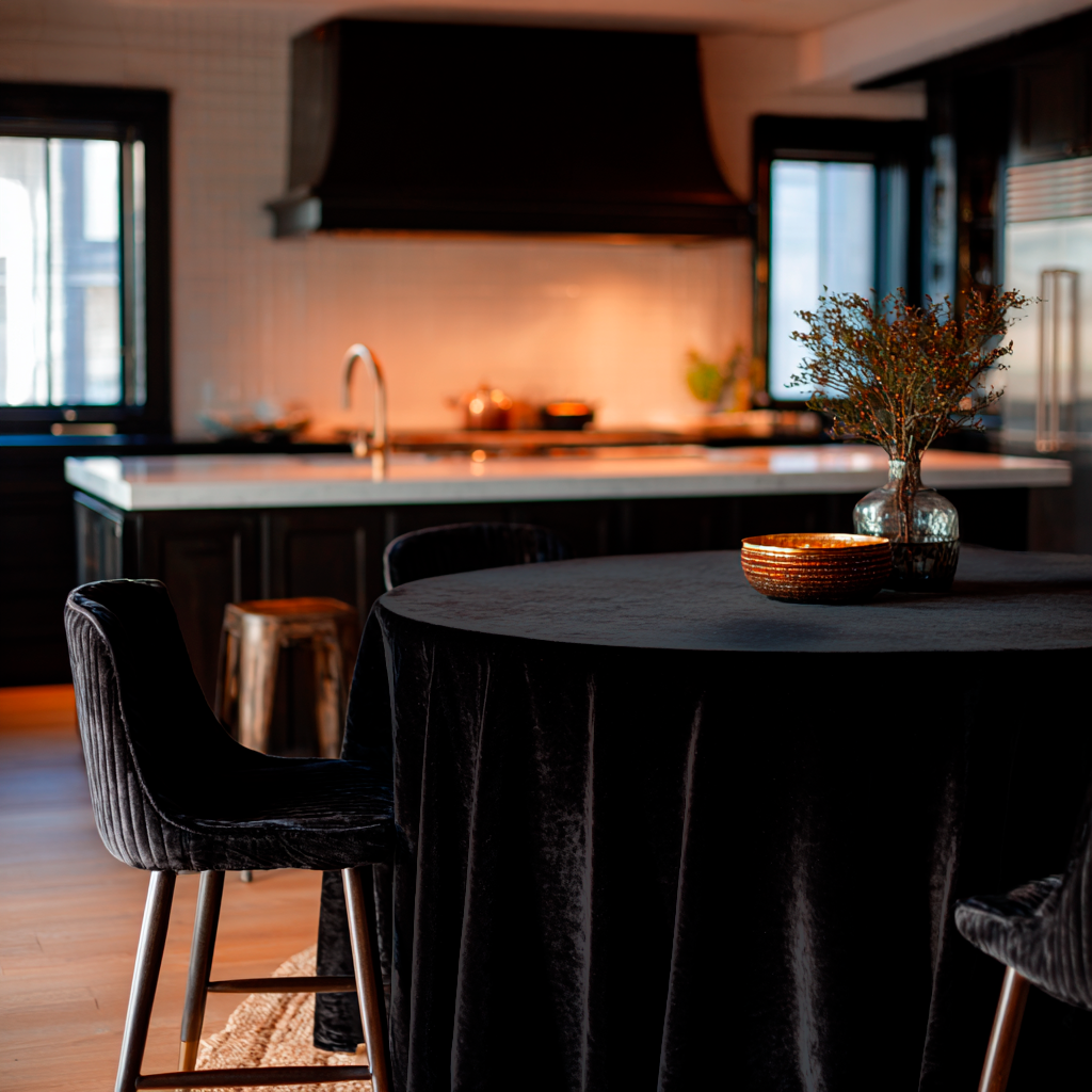 Black Velvet Round Tablecloth in a Moody Kitchen Dining Area with White Tile Walls and Black Cabinetry